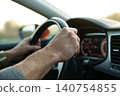 Male hands holding steering wheel while driving 140754855