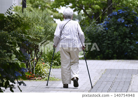 The urban landscape of Yokohama, Japan: A street lined with paved sidewalks and canes... For some reason, there seem to be a lot of elderly women (in macho attire) using canes. 140754948