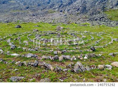 Stone labyrinth on the alpine meadow with green grass among rocks Stone labyrinth on the alpine meadow with green grass among rocks 140755292
