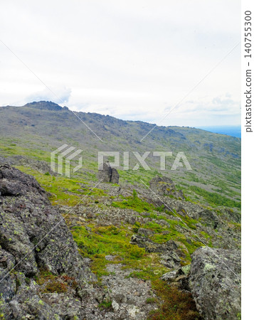 rocky mountain top in summer with green slopes and cloudy sky rocky mountain top in summer with green slopes and cloudy sky 140755300