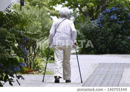 The urban landscape of Yokohama, Japan: A street lined with paved sidewalks and canes... For some reason, there seem to be a lot of elderly women (in macho attire) using canes. 140755349