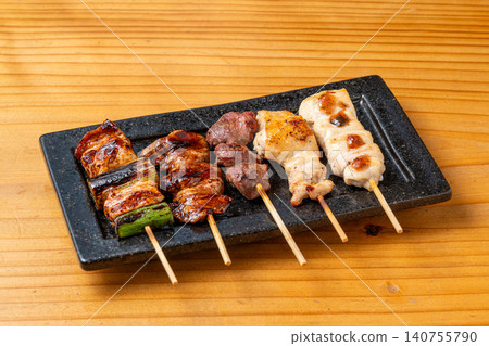 A juicy assortment of grilled chicken skewers, with the aroma of charcoal grilling that will whet your appetite. 140755790