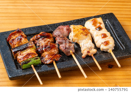 A juicy assortment of grilled chicken skewers, with the aroma of charcoal grilling that will whet your appetite. 140755791