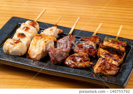 A juicy assortment of grilled chicken skewers, with the aroma of charcoal grilling that will whet your appetite. 140755792