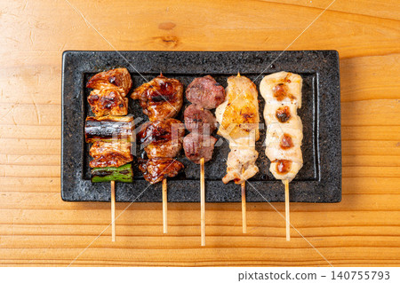 A juicy assortment of grilled chicken skewers, with the aroma of charcoal grilling that will whet your appetite. 140755793