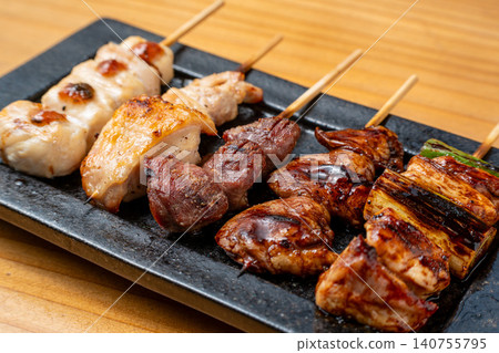 A juicy assortment of grilled chicken skewers, with the aroma of charcoal grilling that will whet your appetite. 140755795