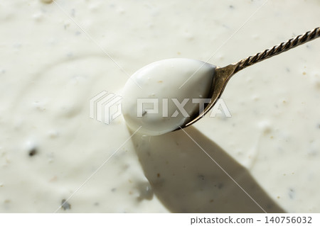 Creamy garlic sauce scoop with herbs texture Creamy garlic sauce scoop with herbs texture 140756032
