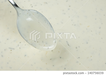 Spoonful of creamy tartar sauce over the bowl, copy space for text Spoonful of creamy tartar sauce over the bowl, copy space for text 140756039