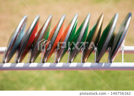 Athletics throw the discus, athletic discs in the rack Athletics throw the discus, athletic discs in the rack 140756162