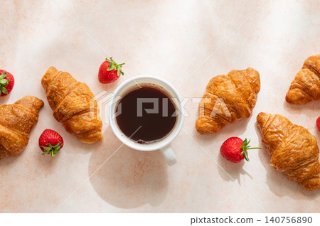 Freshly baked croissants, cup of espresso coffee and strawberries on a bright textured background. Freshly baked croissants, cup of espresso coffee and strawberries on a bright textured background. 140756890