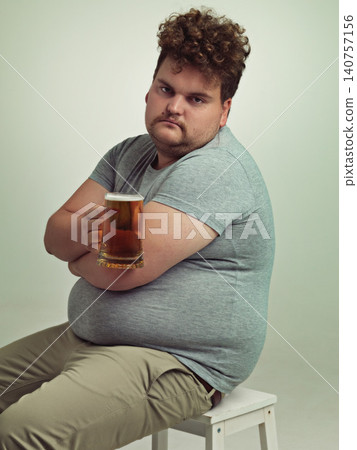 Portrait, arms crossed and plus size man with alcohol for unhealthy habit, serious and weight gain in studio of white background. Face, beer and male person by drink for stomach, calories and carbs Portrait, arms crossed and plus size man with alcohol for unhealthy habit, serious and weight gain in studio of white background. Face, beer and male person by drink for stomach, calories and carbs 140757156