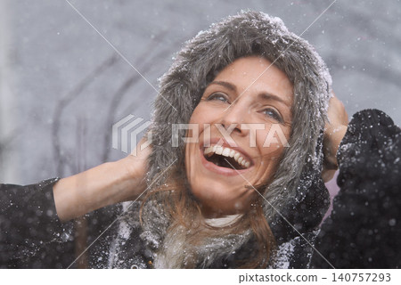 Happy, laughing and face of woman with snow outdoors for season, snowing weather and cold climate. Travel, fashion and person smile in nature on winter holiday, vacation and weekend in Switzerland Happy, laughing and face of woman with snow outdoors for season, snowing weather and cold climate. Travel, fashion and person smile in nature on winter holiday, vacation and weekend in Switzerland 140757293