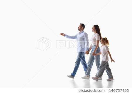 Parents and daughter walking forward on white studio background. Parents and daughter walking forward on white studio background. 140757495