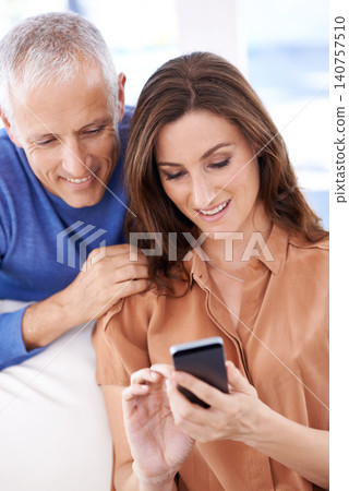 Couple, smartphone and smile on sofa to relax with reading, search and mobile app for contact with bonding. People, woman and mature man with phone for notification, typing or web connection in house Couple, smartphone and smile on sofa to relax with reading, search and mobile app for contact with bonding. People, woman and mature man with phone for notification, typing or web connection in house 140757510