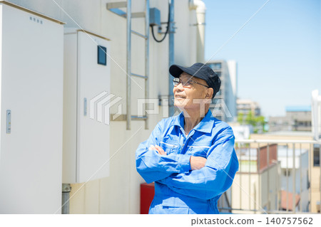 一位老年人在辦公大樓屋頂檢查室外空調機組。 一位老年人在辦公大樓屋頂檢查室外空調機組。 140757562