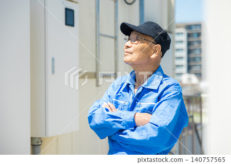 Senior citizen inspecting outdoor air conditioning units on the rooftop of an office building. 140757565