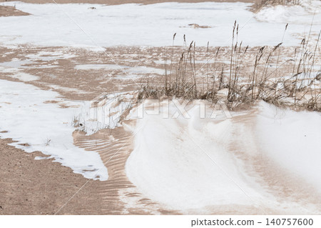 Snow-dusted sand dunes and windswept beach grass Snow-dusted sand dunes and windswept beach grass 140757600