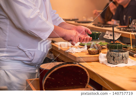 [#Gourmet] A scene from inside the restaurant where a sushi chef prepares food at the counter. 140757719