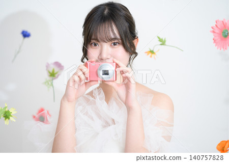 A Japanese woman in a wedding dress holding a digital camera. A Japanese woman in a wedding dress holding a digital camera. 140757828