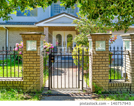 Elegant Brick Pillars and Ornate Wrought Iron Gate Elegant Brick Pillars and Ornate Wrought Iron Gate 140757943