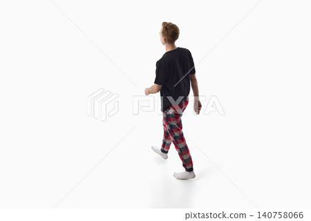 Young man in black shirt and plaid pants walking back view isolated on white background. Young man in black shirt and plaid pants walking back view isolated on white background. 140758066
