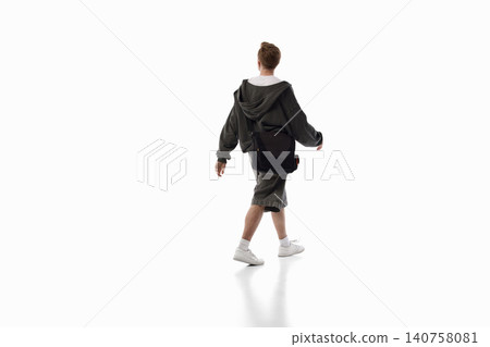 Young man walking away with messenger bag isolated on white background. Young man walking away with messenger bag isolated on white background. 140758081