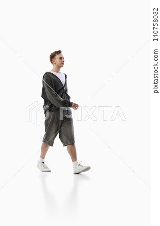 Young man walking in casual streetwear isolated on white background with copy space Young man walking in casual streetwear isolated on white background with copy space 140758082