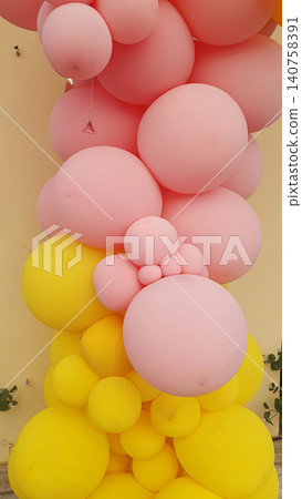 Bright arch of pink and yellow balloons of different sizes for holiday decor. Beautiful photo zone, birthday decoration, party Bright arch of pink and yellow balloons of different sizes for holiday decor. Beautiful photo zone, birthday decoration, party 140758391