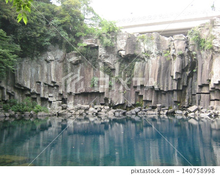 Columnar jointing and the blue river surface of Cheonjeyeon Falls on Jeju Island Columnar jointing and the blue river surface of Cheonjeyeon Falls on Jeju Island 140758998
