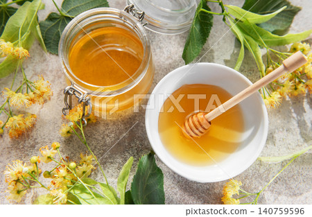 Linden honey jar and bowl with fresh flowers Linden honey jar and bowl with fresh flowers 140759596