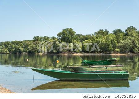 Wooden fishing boats anchored in the calm water of the Rhine River backwater in Germany 140759859