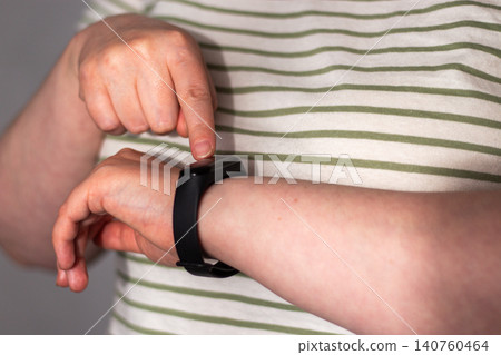 Person glancing at smartwatch briefly then returning to everyday routine. Health data as quiet check not lifeline. Calm tracking without anxiety. Tech supports not controls concept 140760464