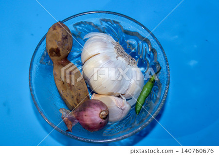 Traditional Indonesian Cooking Ingredients in Glass Bowl on Blue Background 140760676