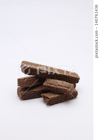 Stack of chocolate wafers rests on clean white background. No people appear in this image. Simple, sweet, and tempting snack for all. Perfect for food blogs, menus, or advertising Stack of chocolate wafers rests on clean white background. No people appear in this image. Simple, sweet, and tempting snack for all. Perfect for food blogs, menus, or advertising 140761436