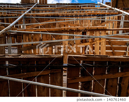 Low angle shot of a building facade covered in construction scaffolding height view Low angle shot of a building facade covered in construction scaffolding height view 140761460