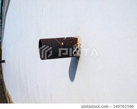 Abstract geometry of rusty metal downspout pipes on a white plaster wall Abstract geometry of rusty metal downspout pipes on a white plaster wall 140761596