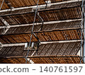 Abstract geometry of scaffolding with a rhythmic shadow pattern on a wall 140761597
