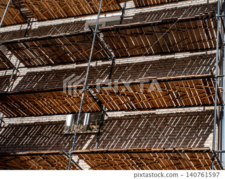 Abstract geometry of scaffolding with a rhythmic shadow pattern on a wall Abstract geometry of scaffolding with a rhythmic shadow pattern on a wall 140761597