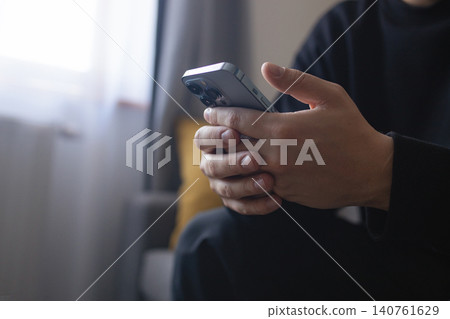 Hands of young person using smartphone indoors close up Hands of young person using smartphone indoors close up 140761629