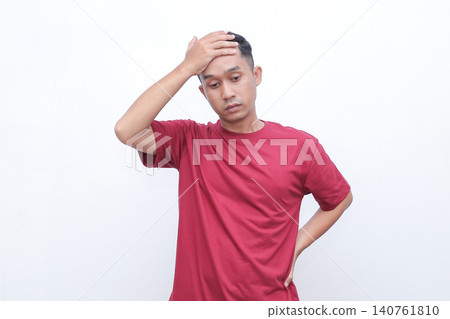 Man shrugs, hands open, showing uncertainty. He wears a simple red tshirt. His expression suggests confusion or indifference. Ideal for situations requiring a gesture of hesitation Man shrugs, hands open, showing uncertainty. He wears a simple red tshirt. His expression suggests confusion or indifference. Ideal for situations requiring a gesture of hesitation 140761810