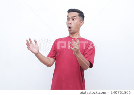 Man wears red tee, shocked expression. Hands raised, mouth open wide. Pure astonishment, dramatic surprise. Studio shot, clean white background. Perfect for reaction, shock, or disbelief scenes 140761865