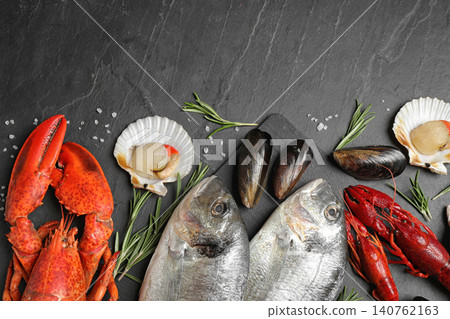 Fresh fish and different seafood on black table, flat lay Fresh fish and different seafood on black table, flat lay 140762163