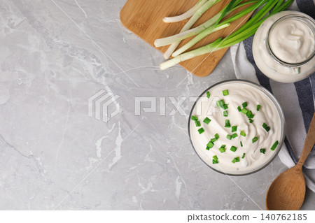 Fresh sour cream with onion on grey marble table, flat lay. Space for text 140762185