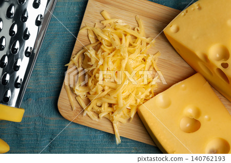 Tasty grated cheese on blue wooden table, flat lay Tasty grated cheese on blue wooden table, flat lay 140762193
