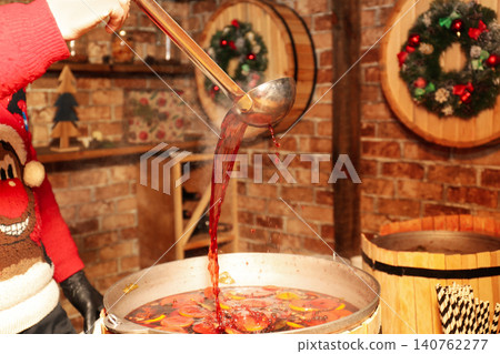 Seller pouring tasty aromatic mulled wine at winter fair, closeup 140762277
