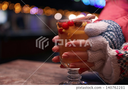 Woman with mulled wine at table, closeup Woman with mulled wine at table, closeup 140762281