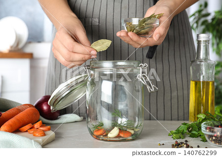 Woman putting bay leaves at marble table, closeup 140762299
