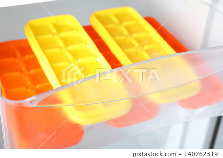 Different plastic ice cube trays in fridge Different plastic ice cube trays in fridge 140762319