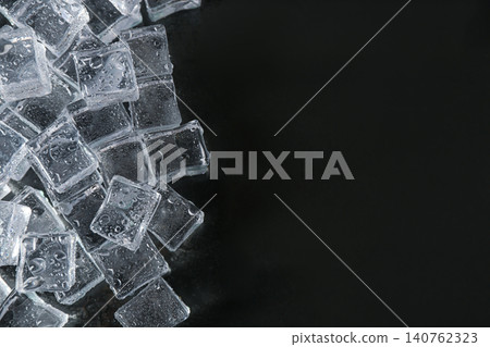 Crystal clear ice cubes with water drops on black background, flat lay. Space for text Crystal clear ice cubes with water drops on black background, flat lay. Space for text 140762323
