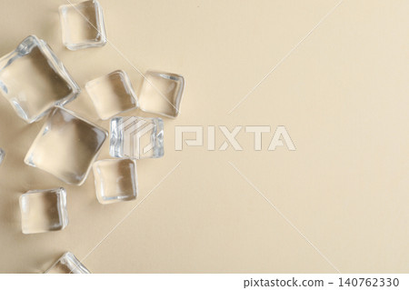 Crystal clear ice cubes on beige background, flat lay. Space for text Crystal clear ice cubes on beige background, flat lay. Space for text 140762330